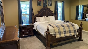A bedroom with a wooden bed, a nightstand, a dresser, and a ceiling fan. - Springfed Canal on Lake George/ Large 4 Bedroom house on water/Boat Ramp/Hot Tub (SaltSprings)
