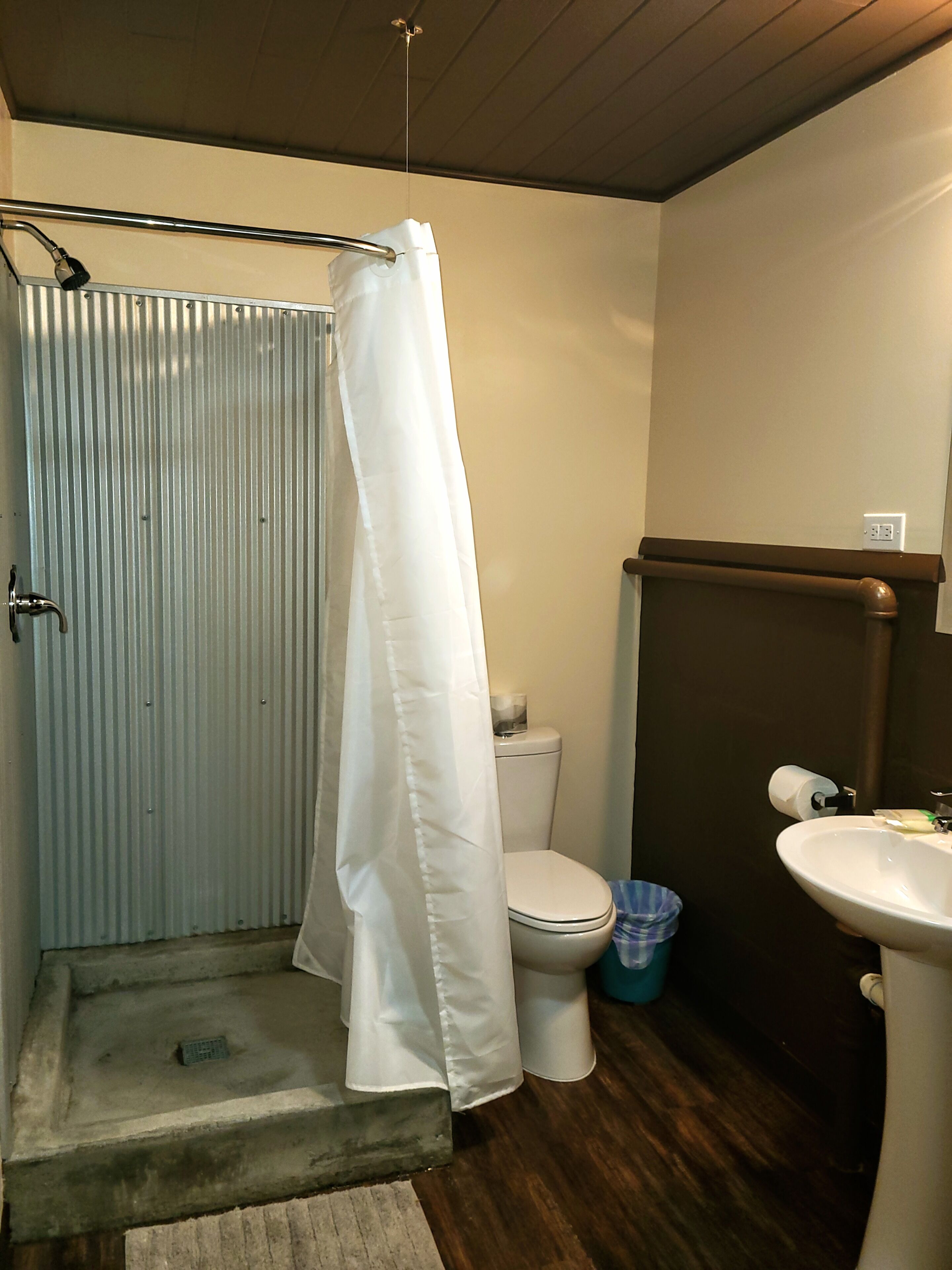 A bathroom with a shower, toilet, and sink.