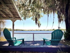 Relax in a serene lakeside setting with a covered seating area, perfect for taking in the tranquil views.