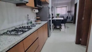 Una cocina moderna con armarios de madera, una estufa a gas y un refrigerador de acero inoxidable.