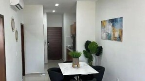 Un comedor moderno con una mesa y sillas, una planta en maceta y un cuadro en la pared.