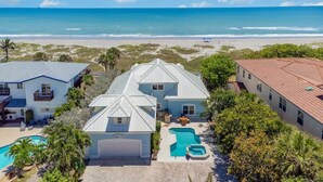 A beachfront property with a large house, a swimming pool, and a view of the ocean. - Sea Watch: 4B/4B Direct Oceanfront Home with Pool Near Downtown Cocoa Beach (Cocoa Beach)
