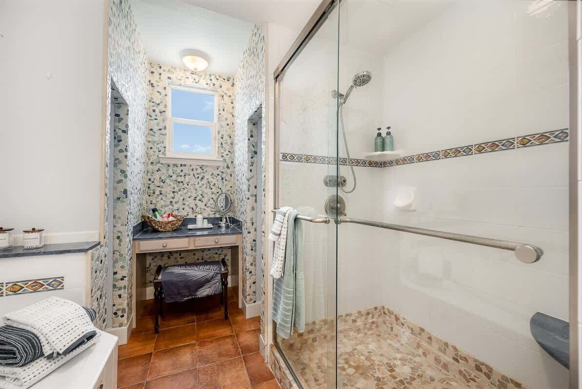 Ein Badezimmer mit Dusche, Waschbecken und Fenster.