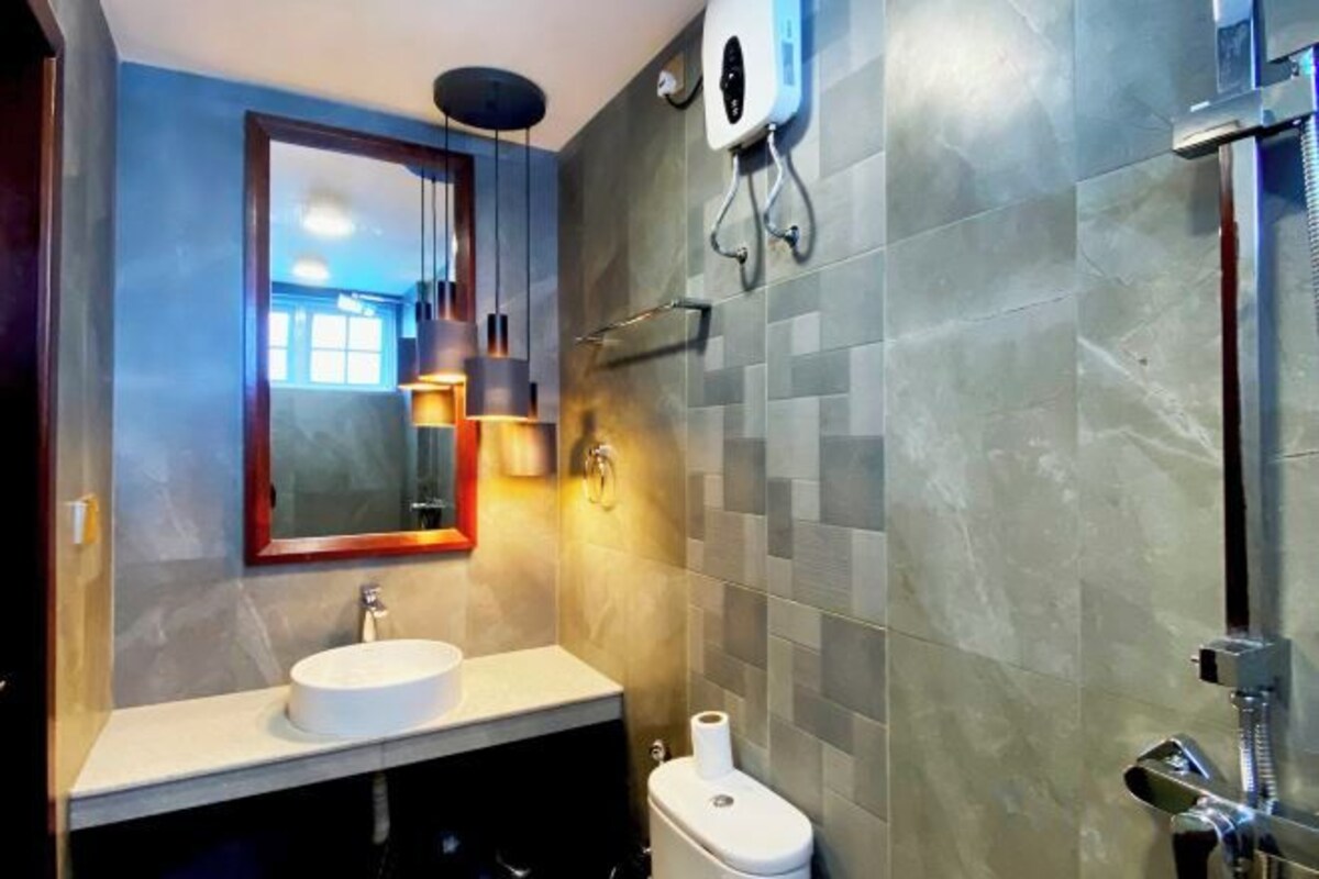A modern bathroom with a sink, toilet, and shower.