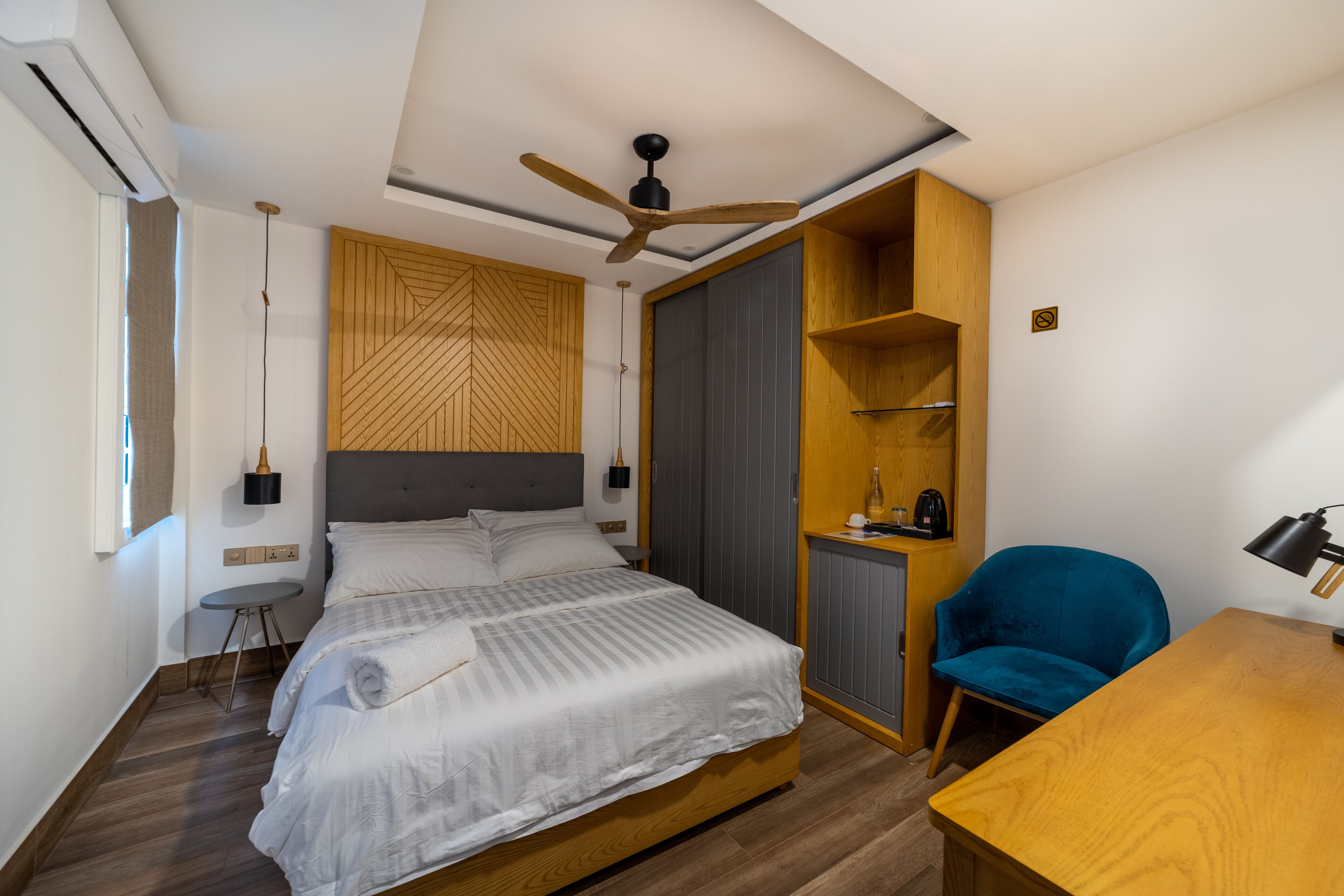 Una camera da letto moderna con un letto, una scrivania, una sedia e un armadio.