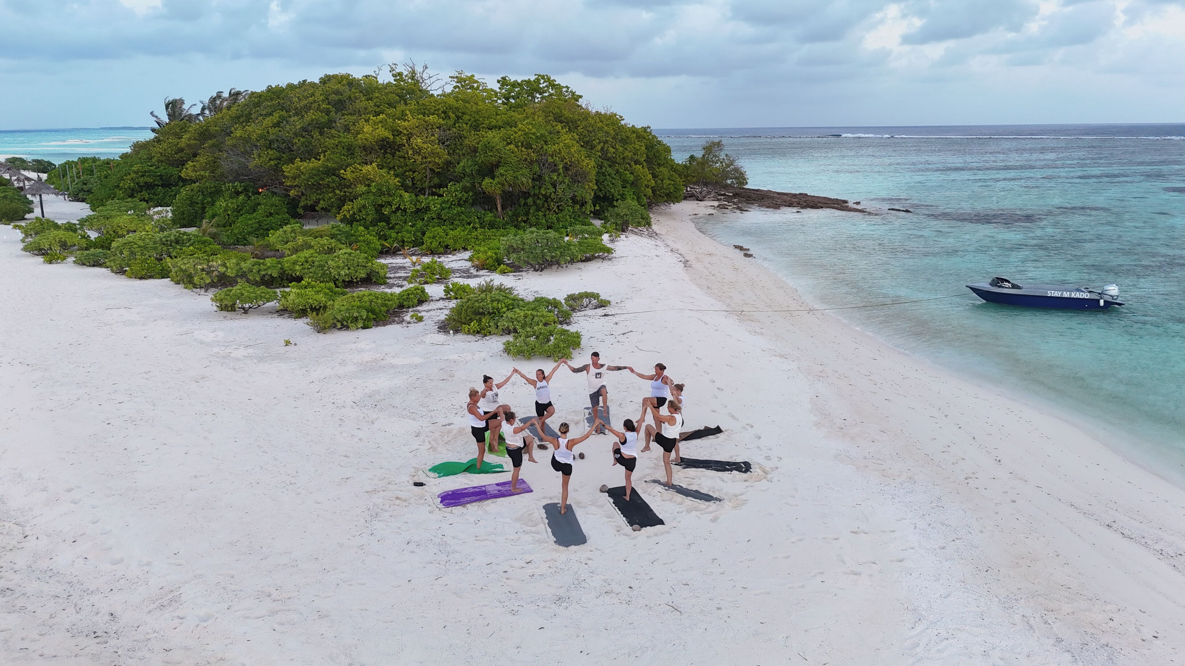 Un grupo de personas en una playa con un bote en el agua.