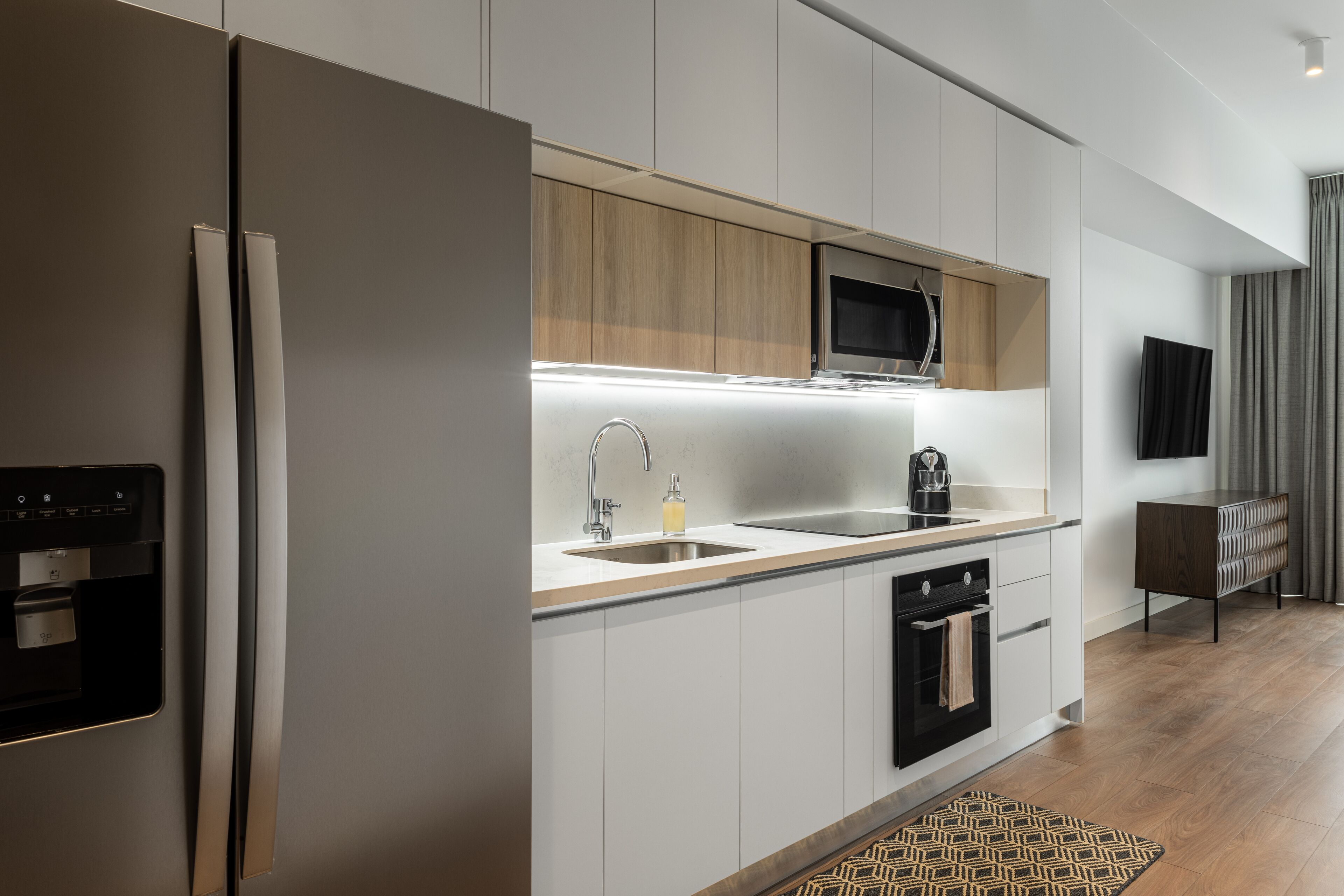 A modern kitchen with a built-in refrigerator, microwave, and oven.