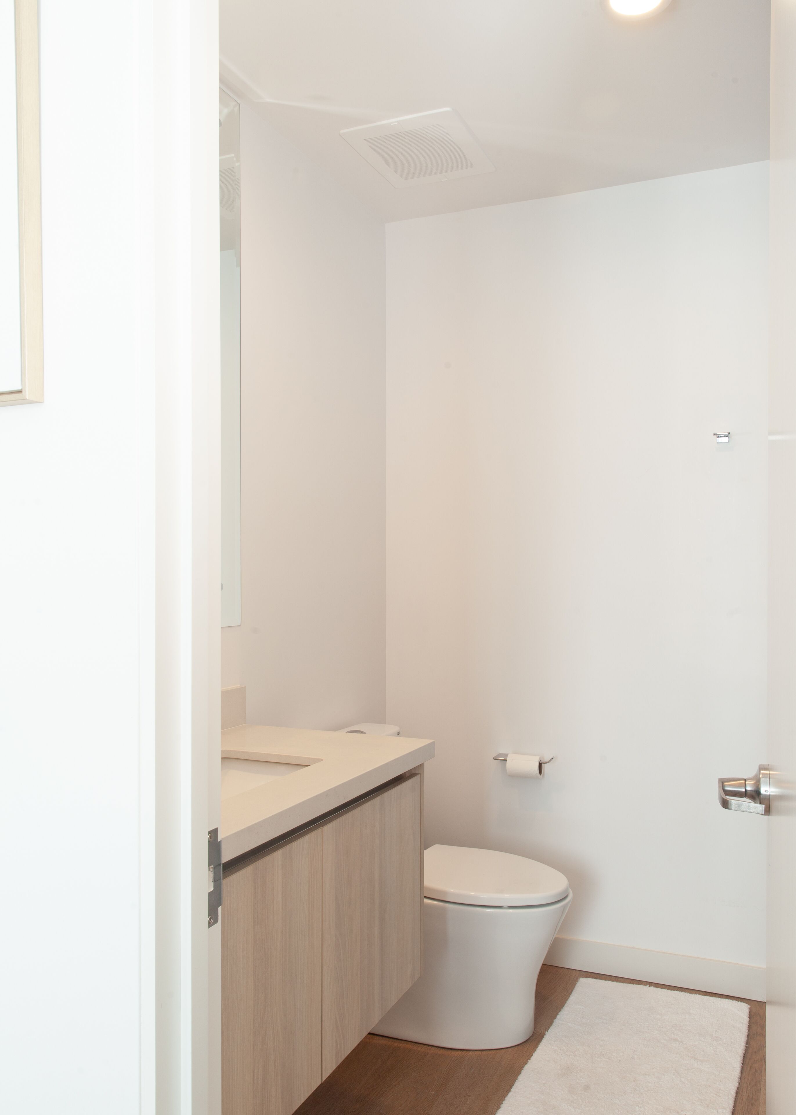 A modern bathroom with a toilet, a sink, and a mirror.