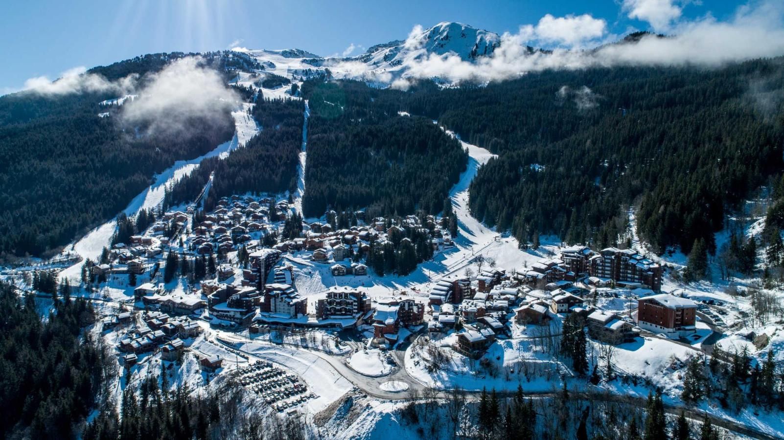 A snow-covered mountain town with buildings clustered along a ski slope.