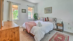 A bedroom with a bed, bedside table, and a wooden dresser.