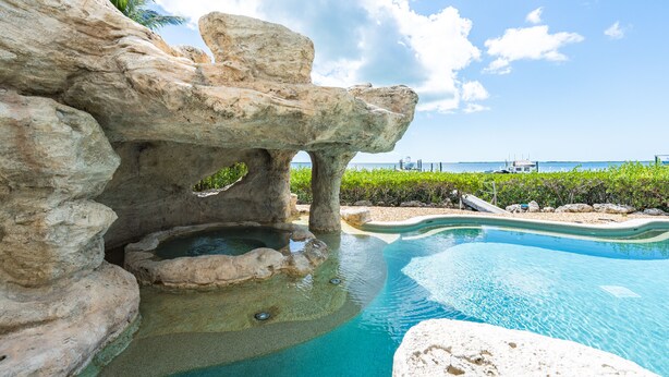 A pool with natural rock formations and a view of the ocean. - Bakers Bay: Key Largo Sunset Haven (Key Largo)