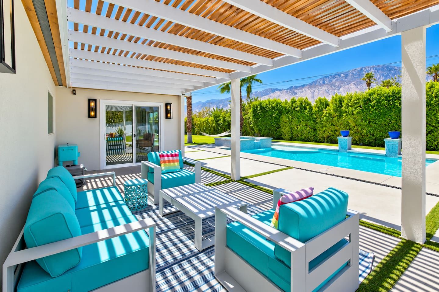 A poolside area with outdoor seating, a pool, and a view of mountains.