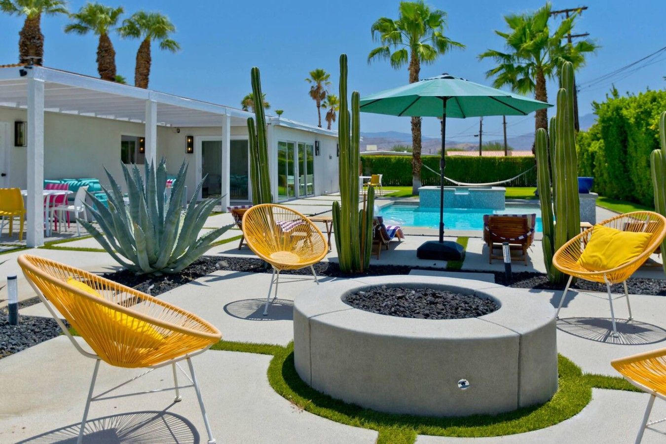 A poolside area with outdoor seating, a fire pit, and a pool.