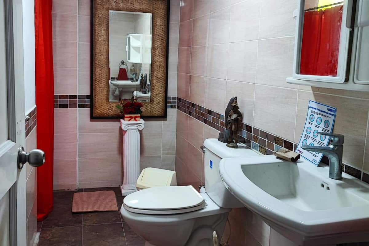 Ein Badezimmer mit Toilette, Waschbecken und Spiegel.