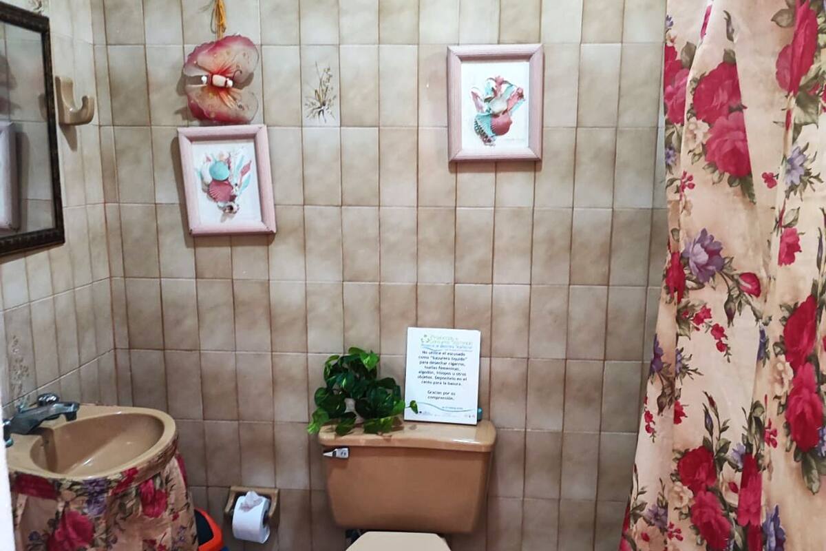 Ein kleines Badezimmer mit Toilette, Waschbecken und einem gerahmten Bild an der Wand.
