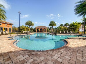 Relax by the pool surrounded by palm trees and lounge chairs.