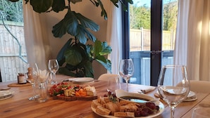 Una mesa de comedor dispuesta con platos de comida, copas de vino y cubiertos.