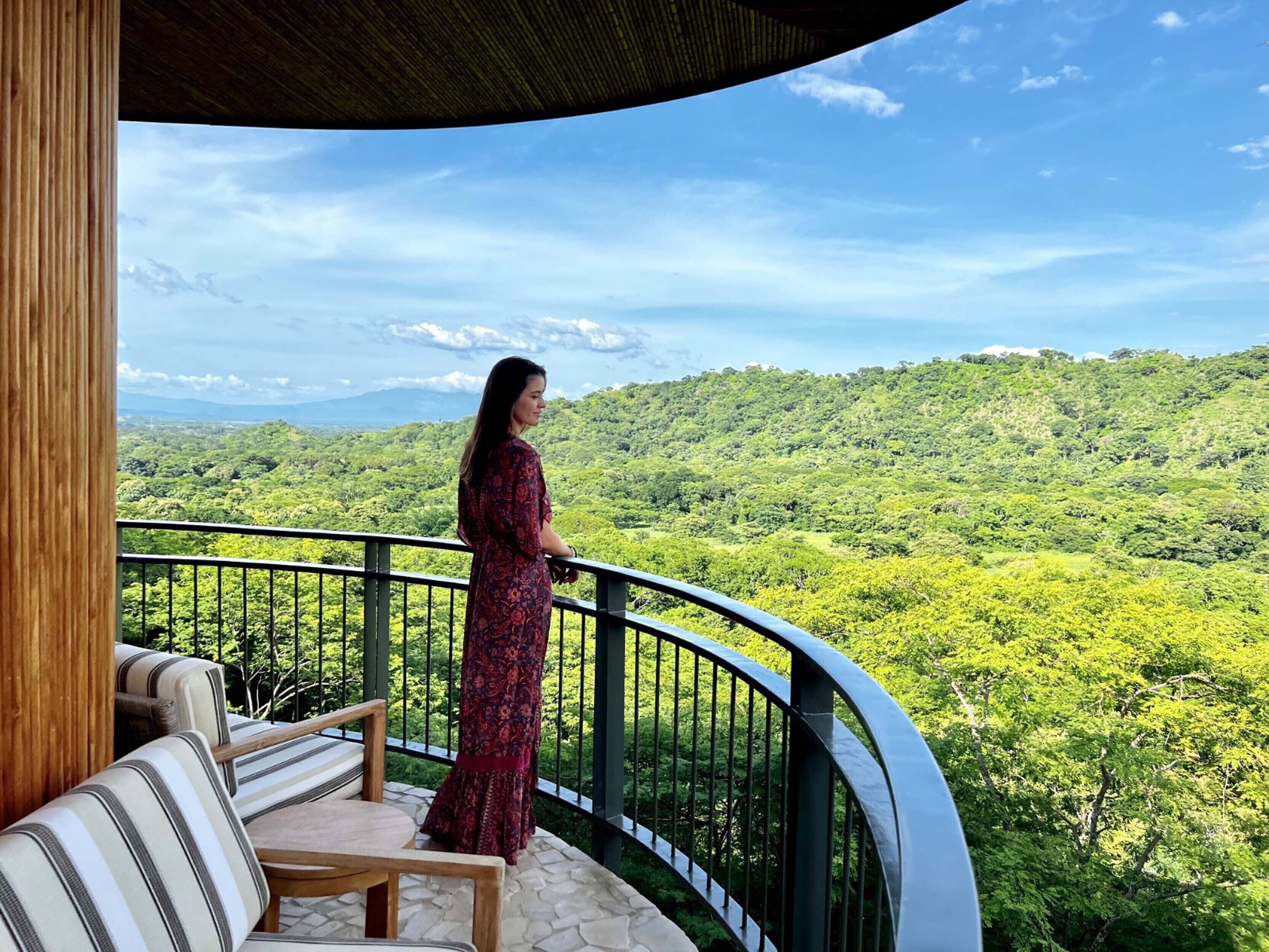 Uma varanda com vista para uma paisagem verdejante.