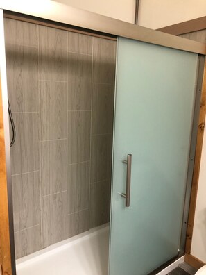 Regadera, secadora de cabello, toallas, papel de baño 