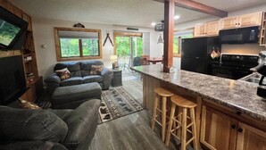 A modern kitchen with granite countertops, wooden cabinets, and a black refrigerator. - Clean, Cozy & Completely Updated! 1B 1B Condo w Jetted Tub Room! (Wakefield)