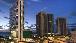 A high-rise hotel with multiple floors, a curved facade, and a view of the surrounding urban area. - Modern Beachfront Condo with Stunning Ocean View (Hollywood)