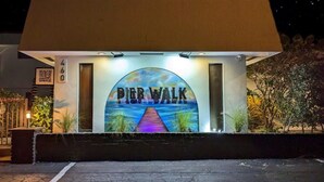 A building with a sign reading "Pier Walk" and a QR code. - 1BR With Updated Kitchen 203 | Sleeps up to 4 (Deerfield Beach)
