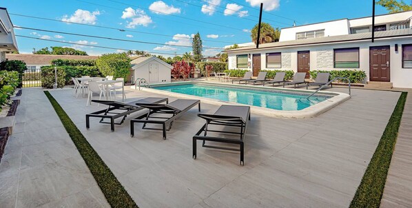 A swimming pool area with lounge chairs and a small building labeled 'Studio #104'.