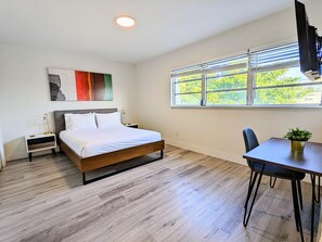 A modern bedroom with a wooden bed, a desk, and a chair.