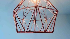 Eine geometrische Pendelleuchte mit freiliegender Glühbirne.