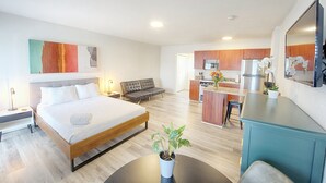 A modern hotel room with a large bed, a small sofa, a kitchenette, and a dining area. - Beach Studio • 482ft Walk • Heated Pool (Deerfield Beach)