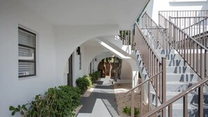 Ein überdachter Gang mit einer Treppe auf der rechten Seite, die zu einer oberen Ebene führt.