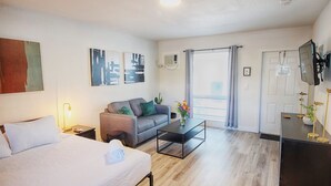 Ein Hotelzimmer mit Bett, Sofa, Couchtisch und Fernseher.