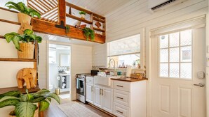 A kitchen with white cabinets, a wooden ceiling, and a window with blinds. - Tiny home 🏡 Northgate- 15min to downtown (Seattle)
