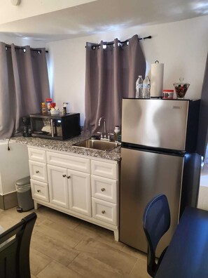 Fridge, microwave, coffee/tea maker, cookware/dishes/utensils