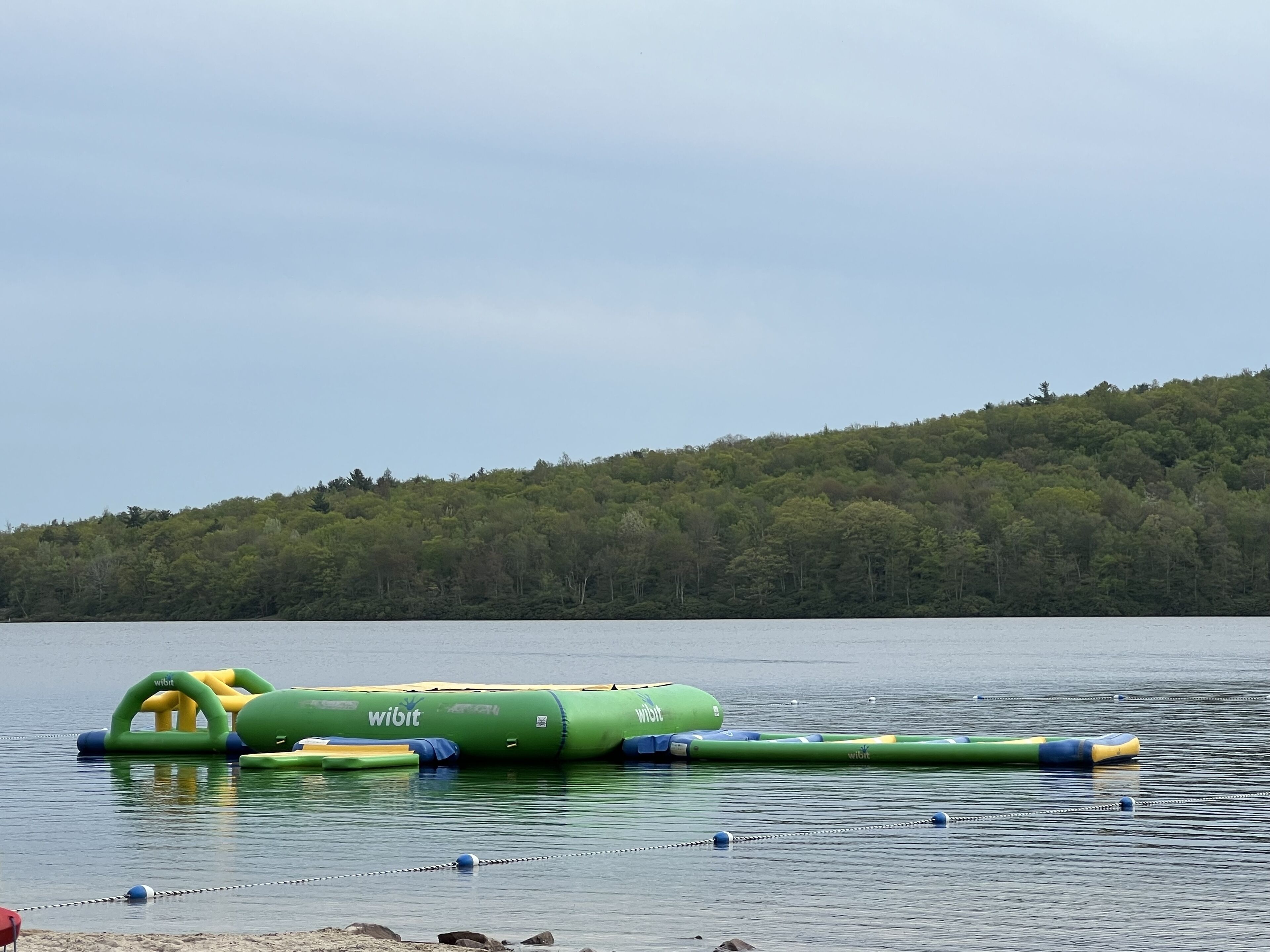 Un lac paisible avec des jeux d’eau gonflables et une barrière en chaîne.