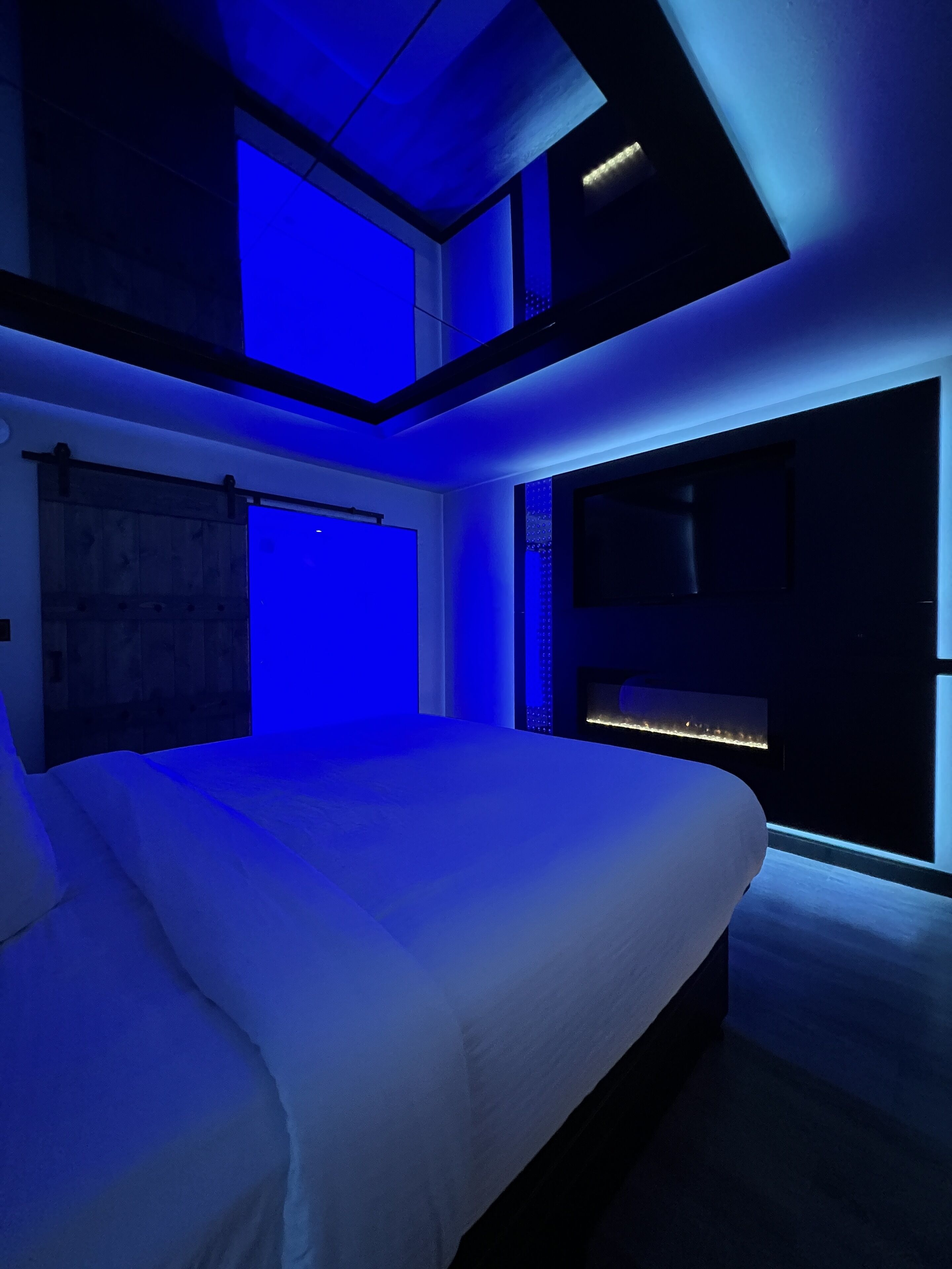 Un dormitorio moderno con una cama grande, tragaluces y vistas a la ciudad.