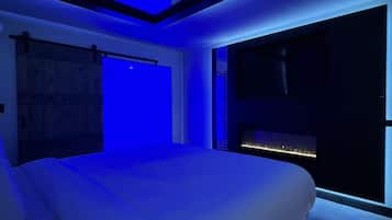 Un dormitorio moderno con una cama grande, tragaluces y vistas a la ciudad.