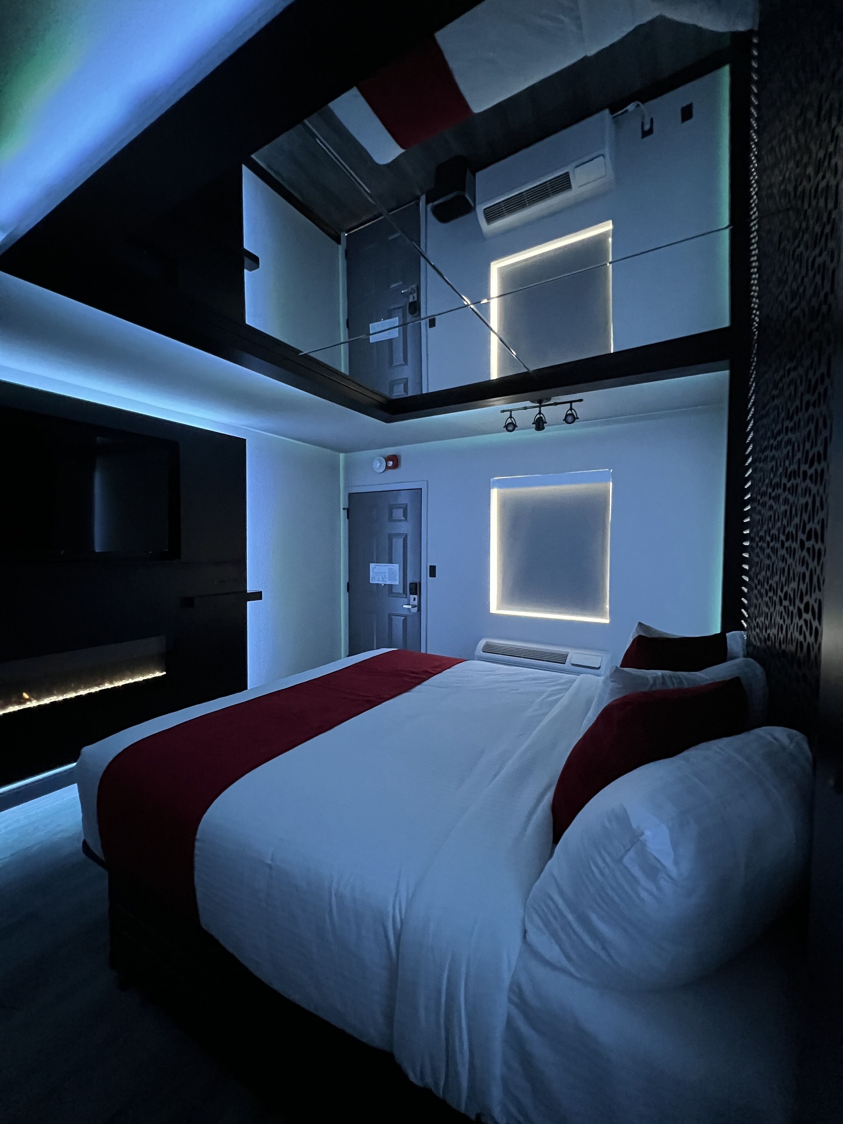 Une chambre d’hôtel moderne dotée d’un grand lit, d’une télévision à écran plat et d’un balcon avec vue.
