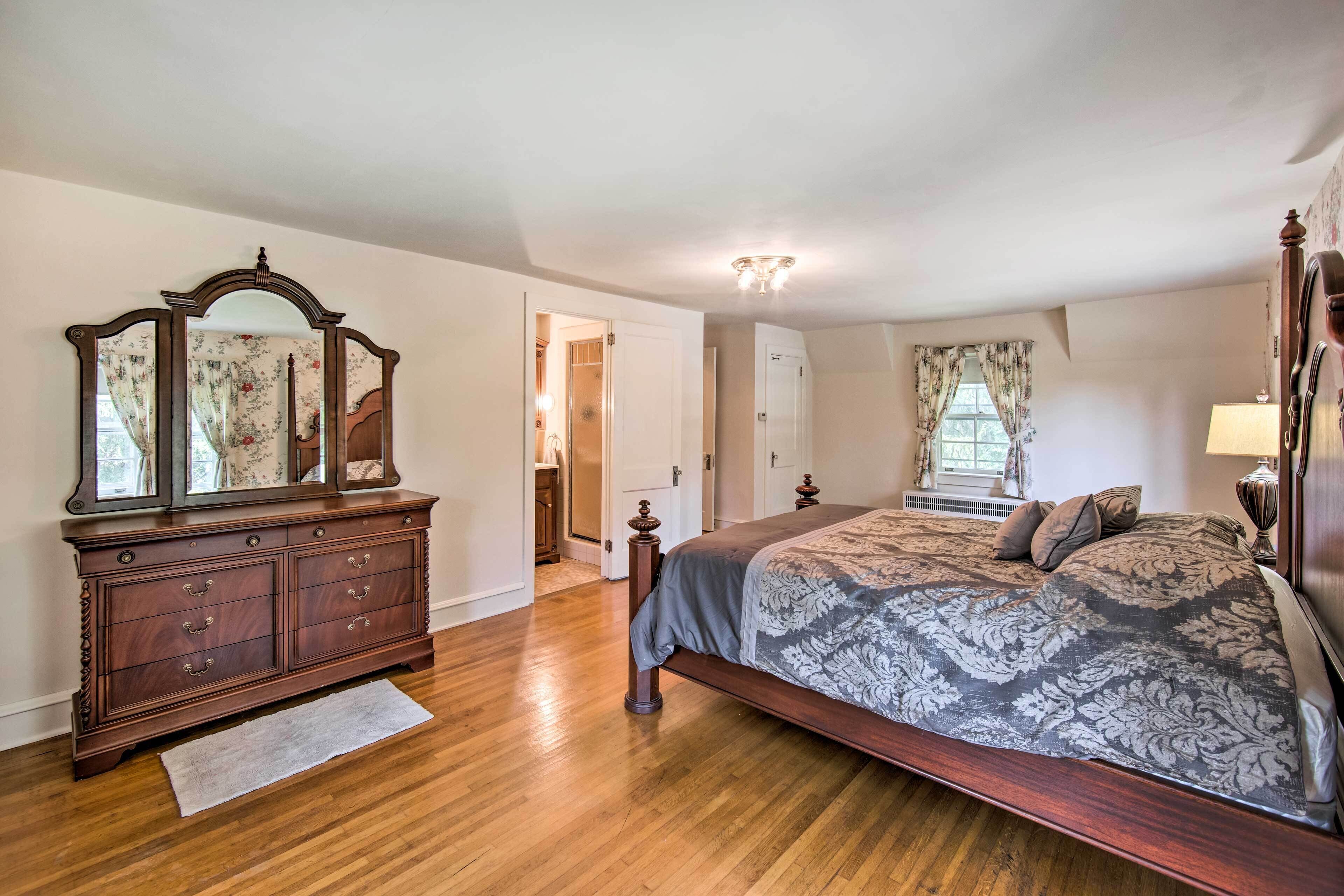 A bedroom with a wooden bed, a dresser, and a mirror.