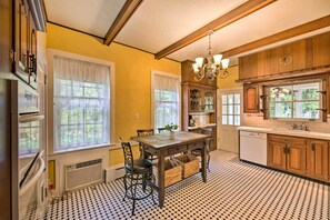 A kitchen with a dining table, chairs, a chandelier, and a window with curtains. - 3-Acre Property: Charming Dutch Country Colonial (Reading)