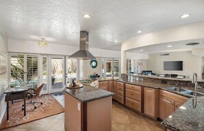 Enjoy cooking in this well-equipped kitchen with a central island, stainless steel range hood, and dishwasher.