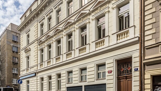 Un edificio storico con facciata classica, numerose finestre e un garage a livello strada.