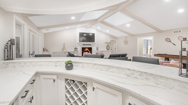 A spacious living area with a curved white marble counter, a fireplace, a television, and seating arrangements. - ★4BR Dallas Family Estate | Heated Pool + Hot Tub | Sleeps 16 | Lake Highlands★ (Dallas)