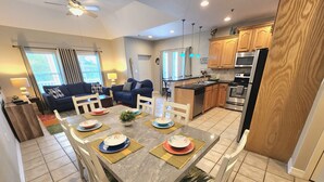 A modern kitchen with wooden cabinets, a built-in oven, and a stainless steel refrigerator. - Cushy Crab, Pool and 3 Minute Walk to Beach!! (South Padre Island)
