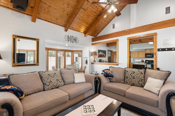 A living room with a sofa set, a coffee table, and a ceiling fan.