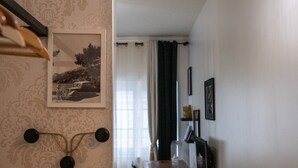 A room with a patterned wallpaper, a framed photograph on the wall, and a table with chairs. - Le Gatsby - Superbe cocon cosy 1mn place Bellecour (Lyon)