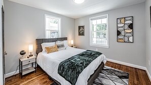 Een slaapkamer met een bed, nachtkastjes, een wereldbol en een lamp.