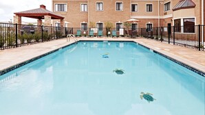 A rectangular swimming pool with a tiled edge, a gazebo, and a brick building in the background. - 1 Bedroom | Free Breakfast, Pool Access (Oklahoma City)
