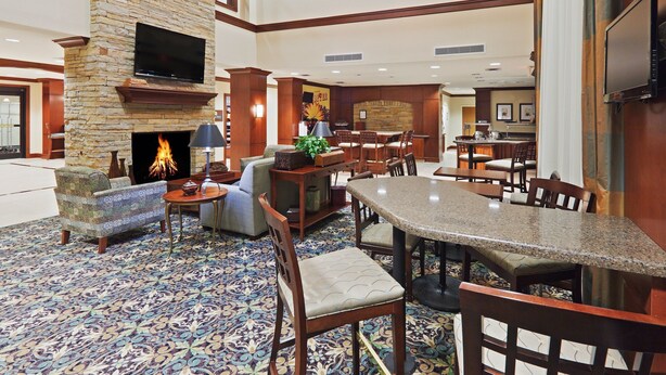 A spacious lobby with a fireplace, comfortable seating, a bar area, and a television mounted on the wall. - 1 Bedroom | Free Breakfast, Pool Access (Oklahoma City)