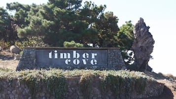A stone sign with the text "timber cove" surrounded by natural scenery.
